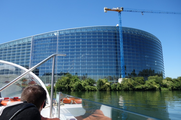 Das moderne Gebäude des Europäischen Parlaments mit seiner markanten Glasfassade, gesehen vom Wasser aus