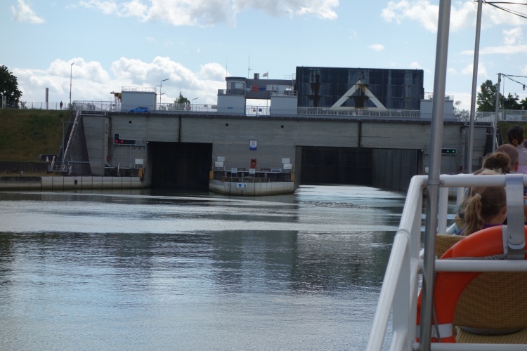 Blick auf ein großes Schleusentor einer Schiffsschleuse während einer Bootsfahrt auf dem Rhein