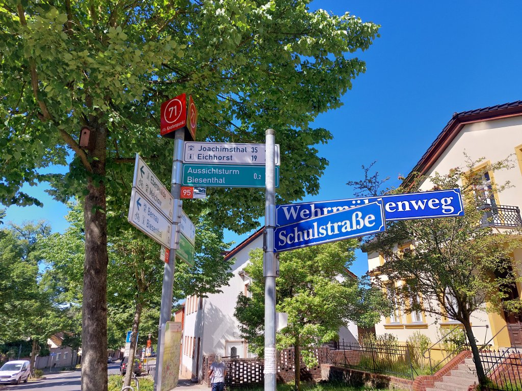 Ein blauer Wegweiser an einer Kreuzung, der den Weg zu lokalen Sehenswürdigkeiten weist
