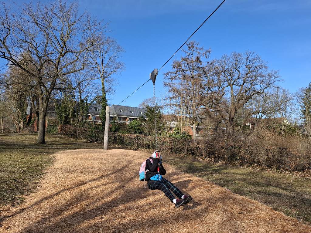 Christina hat Spaß bei einer Fahrt mit der Seilbahn auf dem Spielplatz an der Kleinen Badewiese