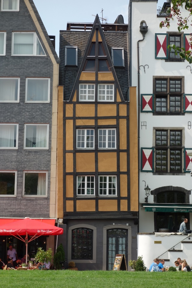 Ein schmales, hohes Fachwerkhaus inmitten der Kölner Altstadtgasse