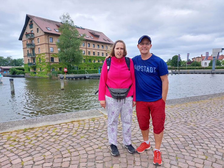 Christina und Andreas posieren lächelnd vor der Kulisse des Stadthafens Neustrelitz