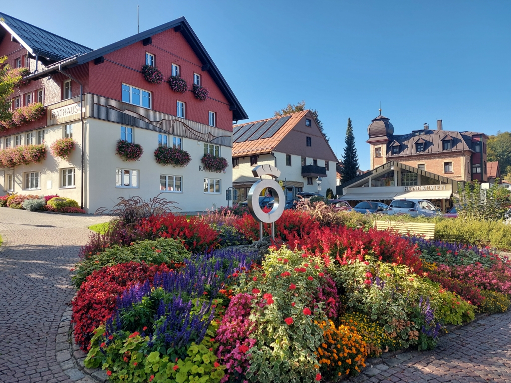 Ein blumengeschmückter Platz in Oberstaufen mit Blick auf traditionelle bayerische Häuser