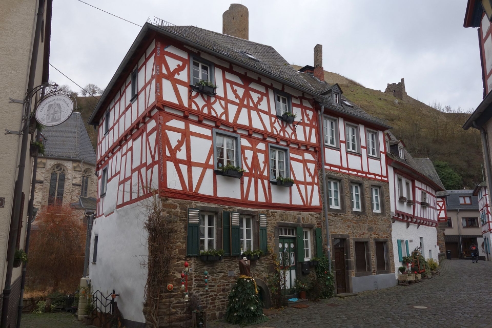Detailansicht eines prächtigen Fachwerkhauses mit kunstvollen Schnitzereien und Blumenkästen