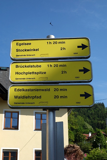 Gelbe Wanderschilder in Unterach am Attersee, die den Weg zum Edelkastanienwald und nach Stockwinkel weisen