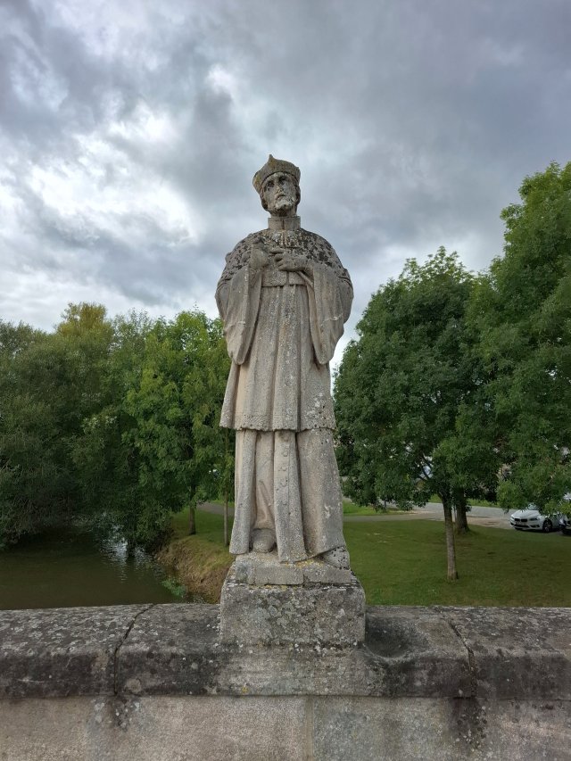 Historische Statue einer Heiligenfigur in einer Grünanlage
