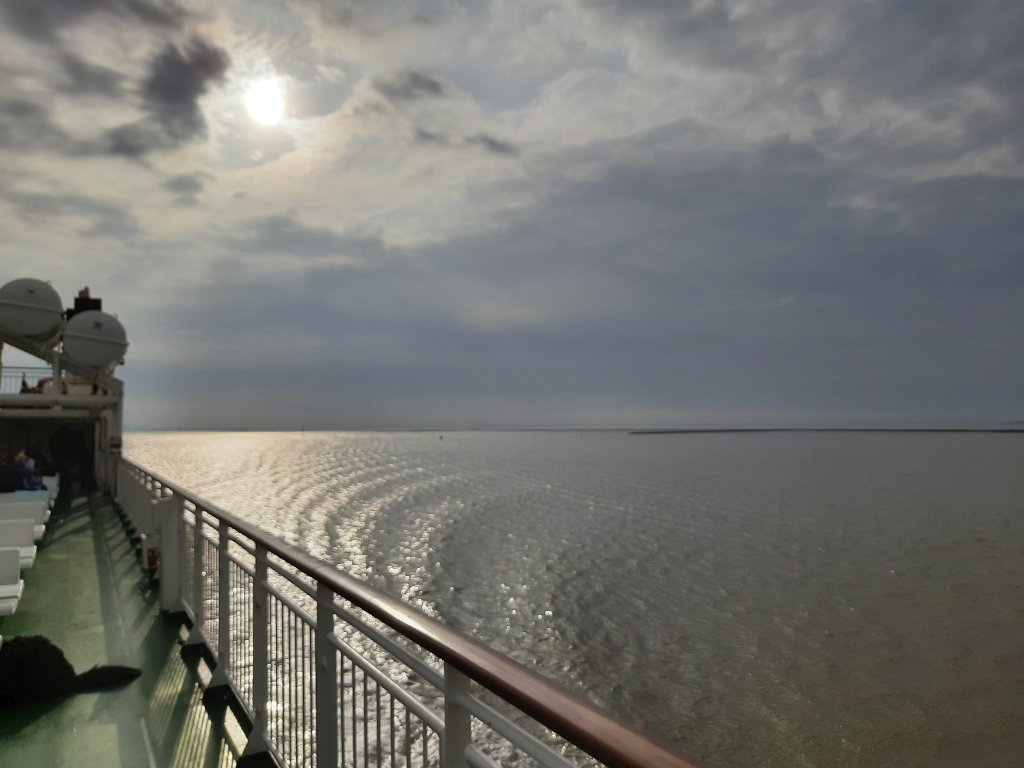 Blick über die Reling auf die offene Nordsee und das Kielwasser