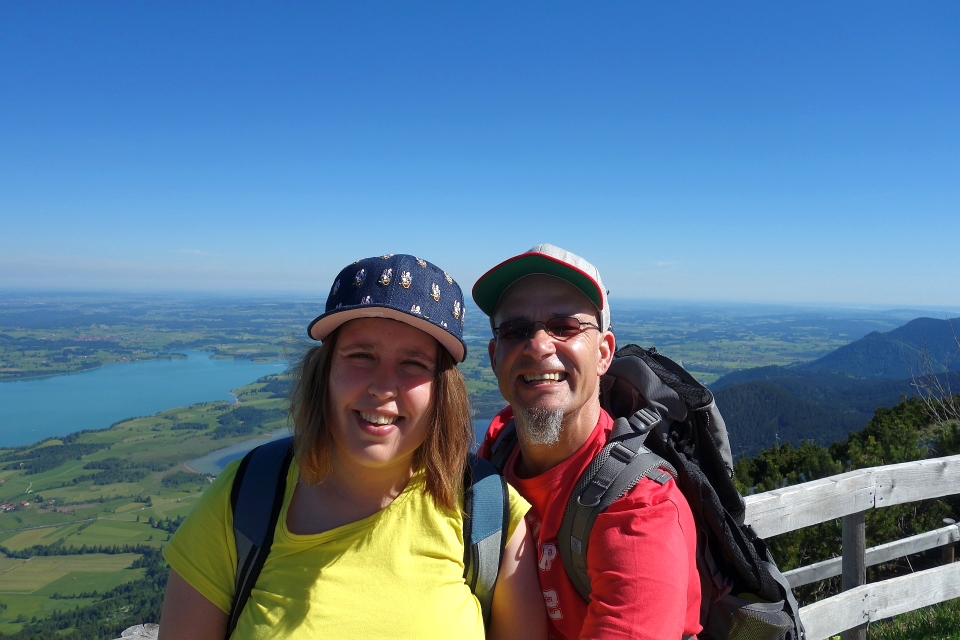 Andreas und Christina lächeln bei strahlendem Sonnenschein auf dem Gipfel