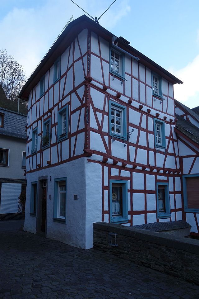 Blick auf die Giebelseite eines großen Fachwerkhauses unter bewölktem Himmel