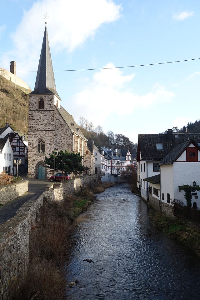 Eine Perspektive durch die Gassen auf die umliegenden grünen Hügel der Eifel
