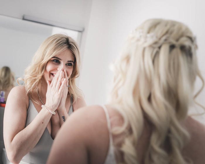 emotionale Hochzeitsfotos Freude der Trauzeugin beim Anblick des Brautkleides - Hochzeitsfotograf für echte Reportagen