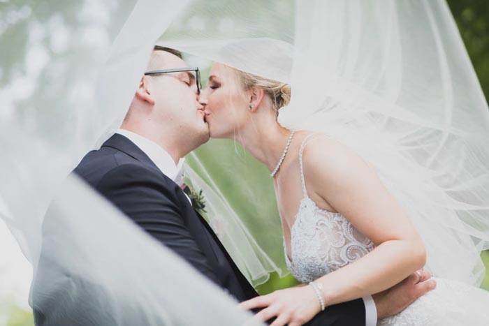 Hochzeitsfotografie Bonn Outdoor Hochzeit Hochzeitskuss unter dem Hochzeitsschleier - Hochzeitsfotograf in Köln