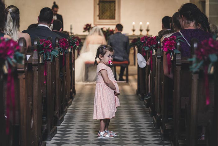 Hochzeitsfotograf kirchliche Hochzeit in St. Antonius in Siegburg Kind steht im Mittelgang der Kirche