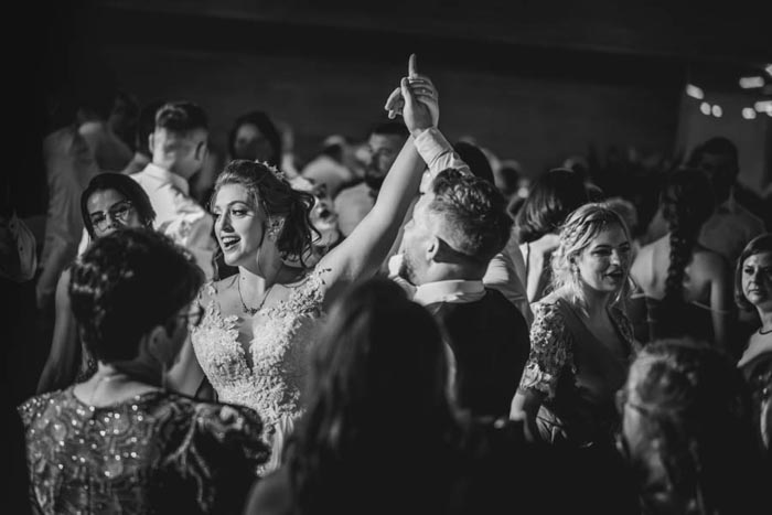 Braut tanzt mit Bräutigam in schwarz weiß - Hochzeitfotograf für lebendige Partyshots