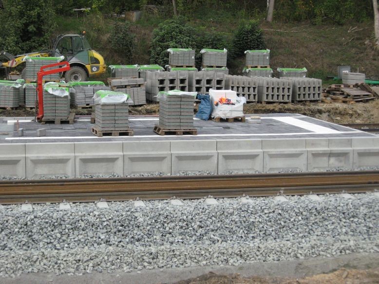 Verlegte Platten auf dem Mittelbahnsteig - weiße Stop-Linien