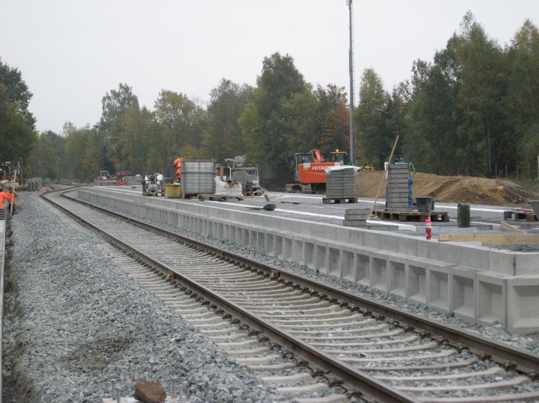 Mittelbahnsteig größtenteils gepflastert und Funkmast im Hintergrund