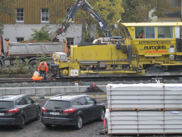 Schotterplanierraupe - dahinter Arbeiten auf der Bahnhofstraße