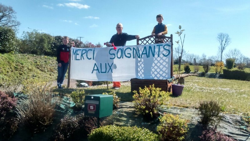 Alain Galleteau peint une pancarte pour les soignants.