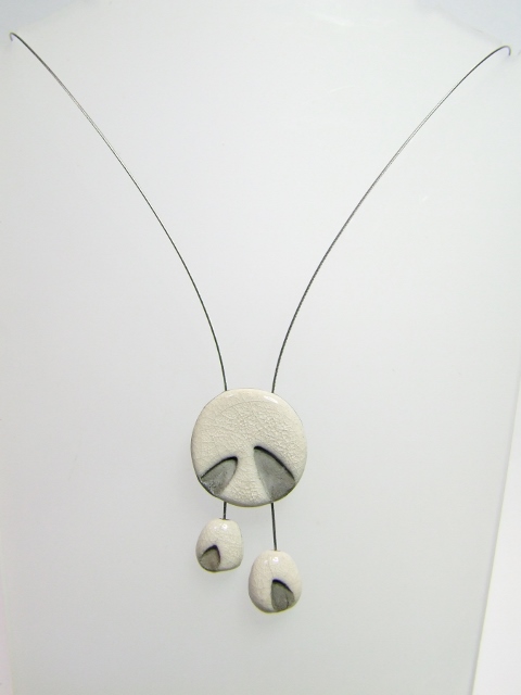 Collier avec une perle sous laquelle sont suspendues deux autres petites perles vu de face