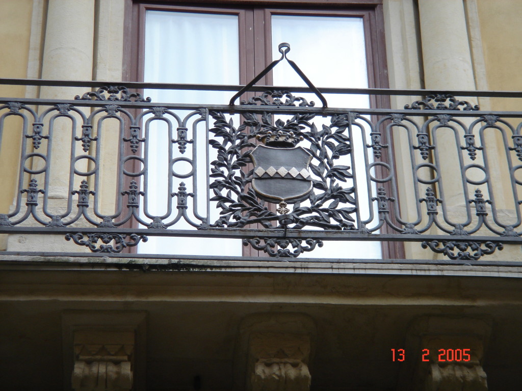 Il balcone centrale. Particolare dello stemma nobiliare stemma dei Cirino (Cinque losanghe su fondo dorato corona di baroni e croce di cavalieri di Malta).