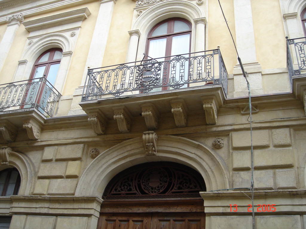 Il balcone centrale del piano nobile di Palazzo Cirino che sormonta il portale. Con stemma del casato