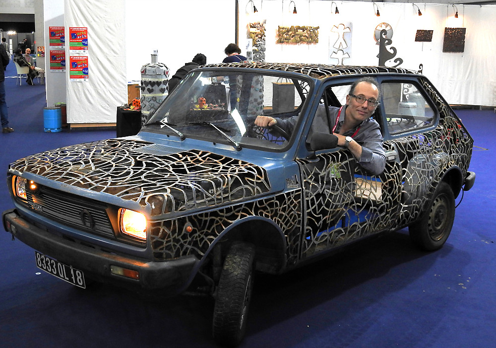 Fiat 127 sculptée avec l'artiste à son bord