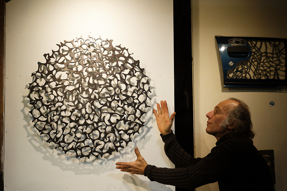 Tableau en acier de forme circulaire et en présence de l'artiste