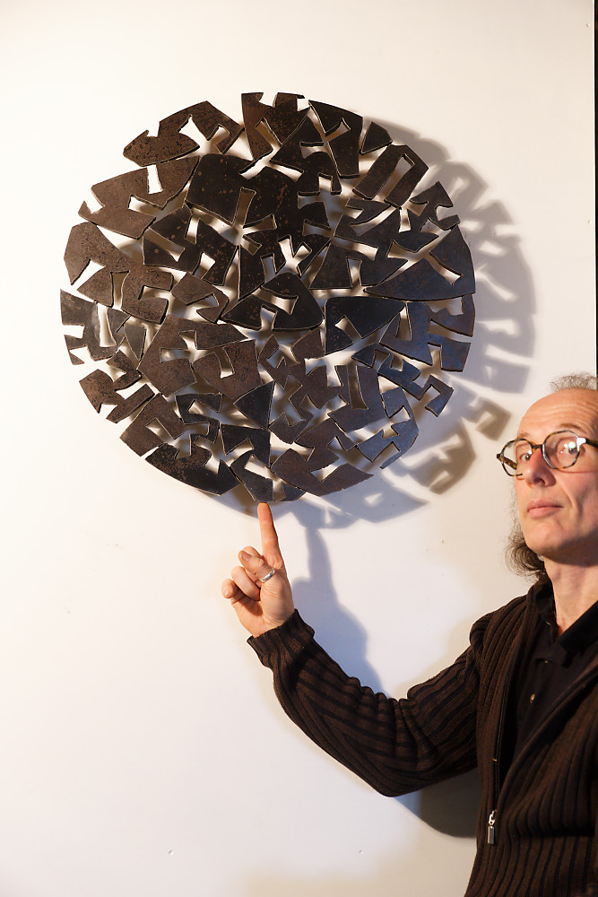 Tableau circulaire en acier en présence du sculpteur
