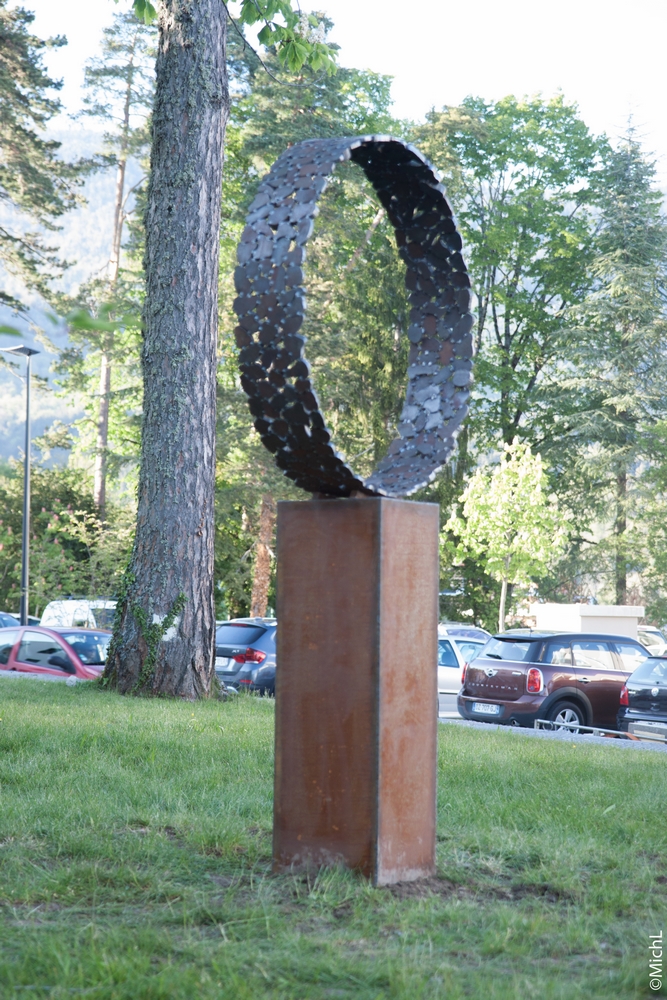 Sculpture en acier en forme d'anneau dans un parc