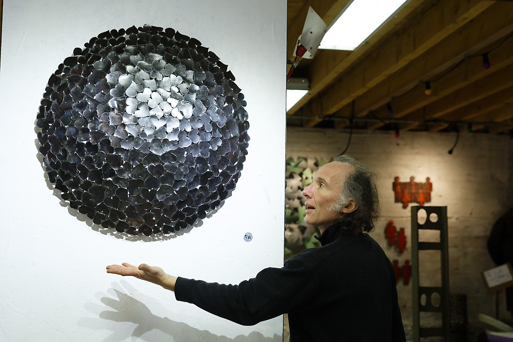 Tableau en acier brut de forme circulaire et en présence de l'artiste