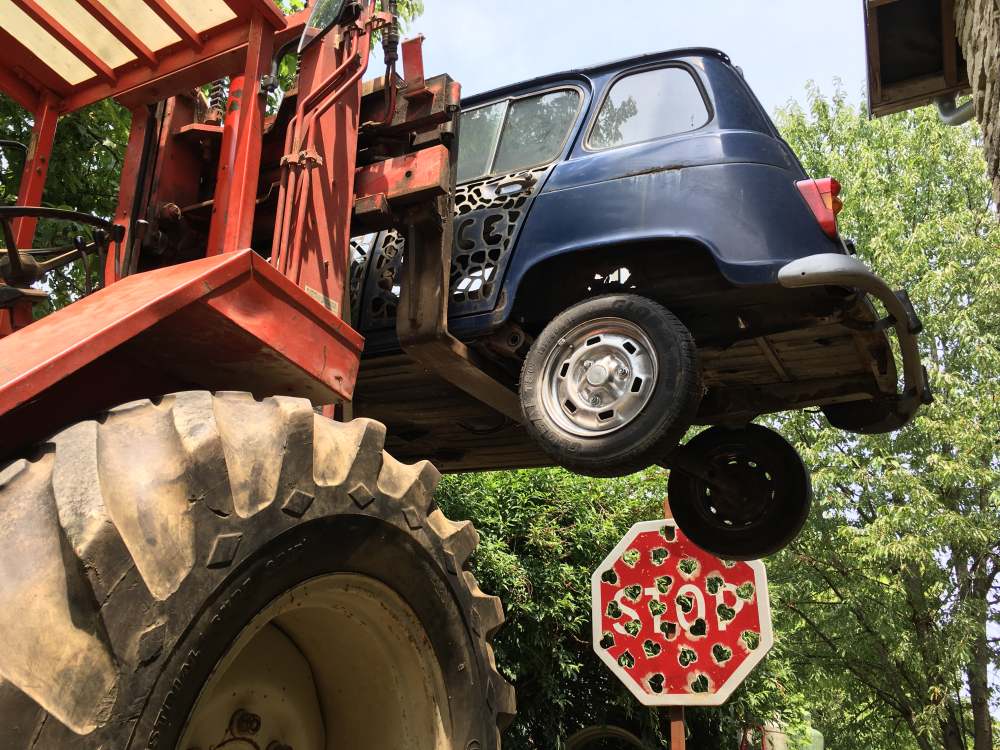 Renault 4 portée par un engin