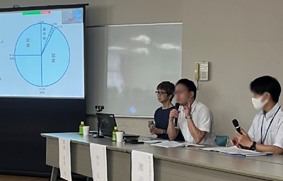 スクリーンに投影しんがら社員が講演する様子の写真1