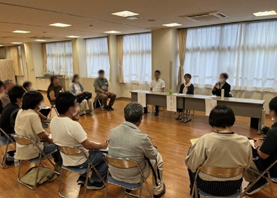 参加者と輪になって座っている様子の写真