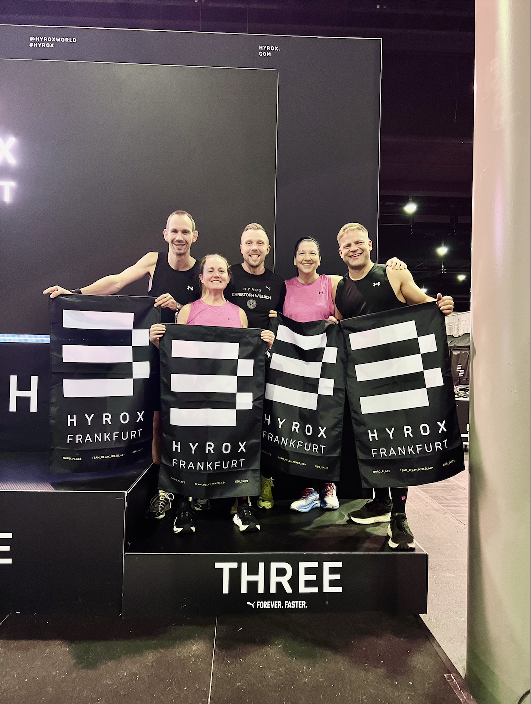 HYROX Frankfurt Siegerehrung: Relay-Team auf dem Podium (3. Platz Altersklasse). Christoph Wieloch, Personal Trainer und HYROX Coach aus Frankfurt.