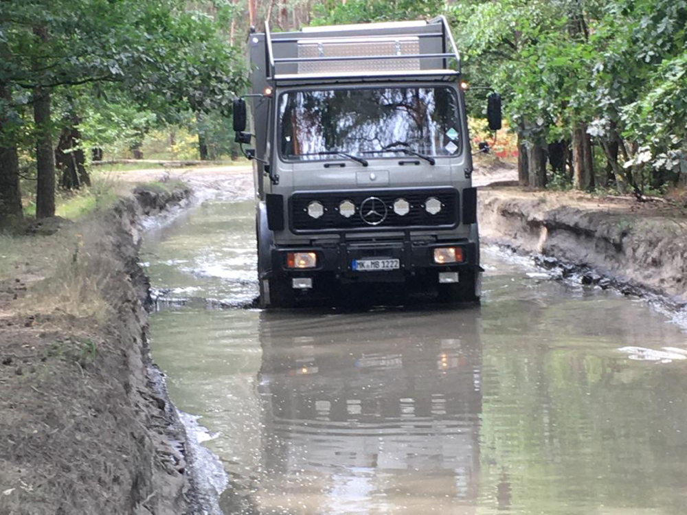 LKW übt Wasserdurchfahrt im schwierigen Gelände beim Offroadkurs