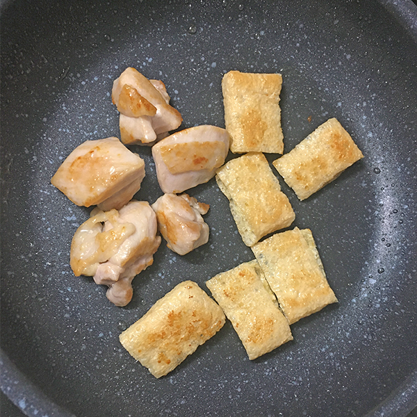 フライパンに油をひいて鶏肉と油揚げを油で炒めます