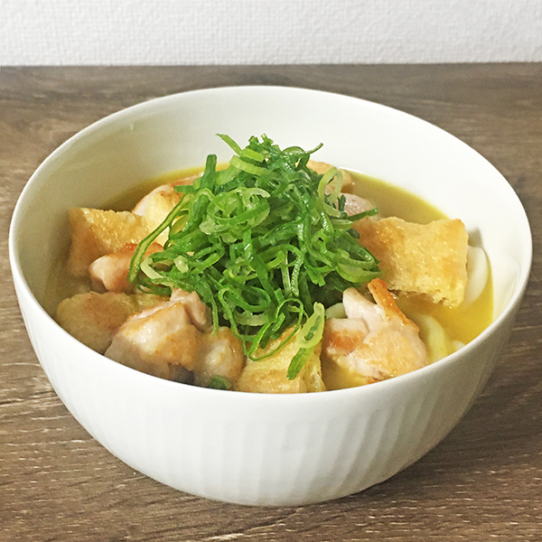 茹で上がったうどんにカレーをかけて、炙った鶏肉と油揚げ、刻んだ九条ネギをのせて完成です
