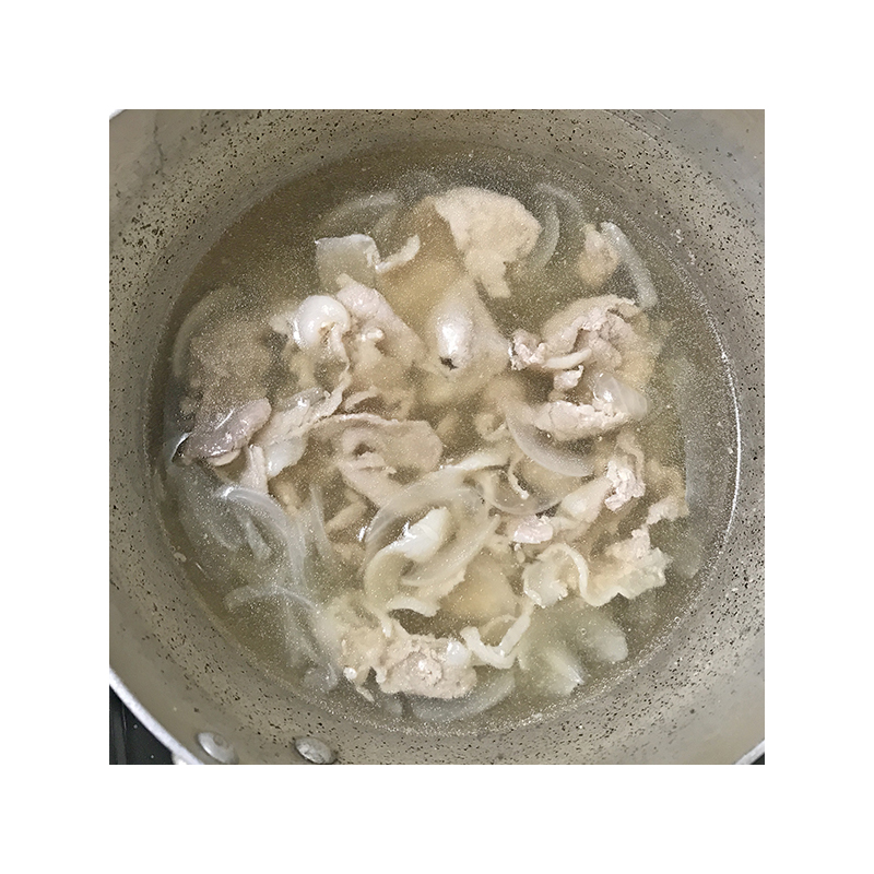 鍋に入れた鶏ガラスープ300ccで豚肉と玉ねぎを煮て、火が通ったらアク取りをします