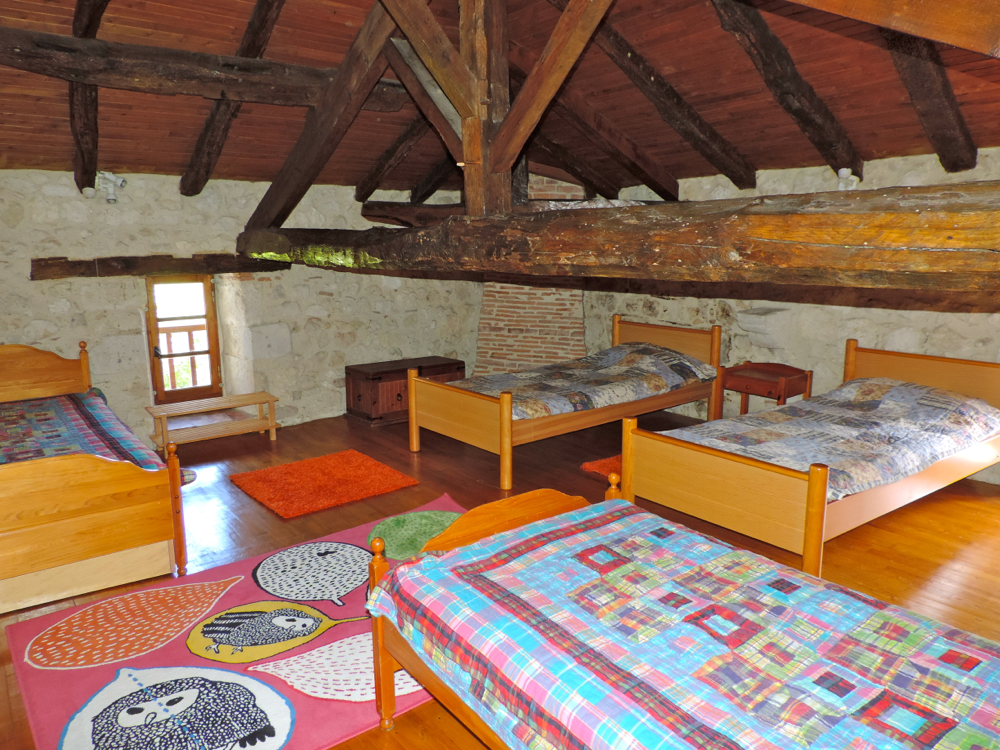 Grande chambre sous les poutres, idéale pour les enfants car les  2 lits sont placés  avant une poutre centrale.