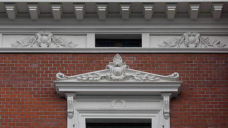 Detailausschnitt der Fensterbekrönung und Attika