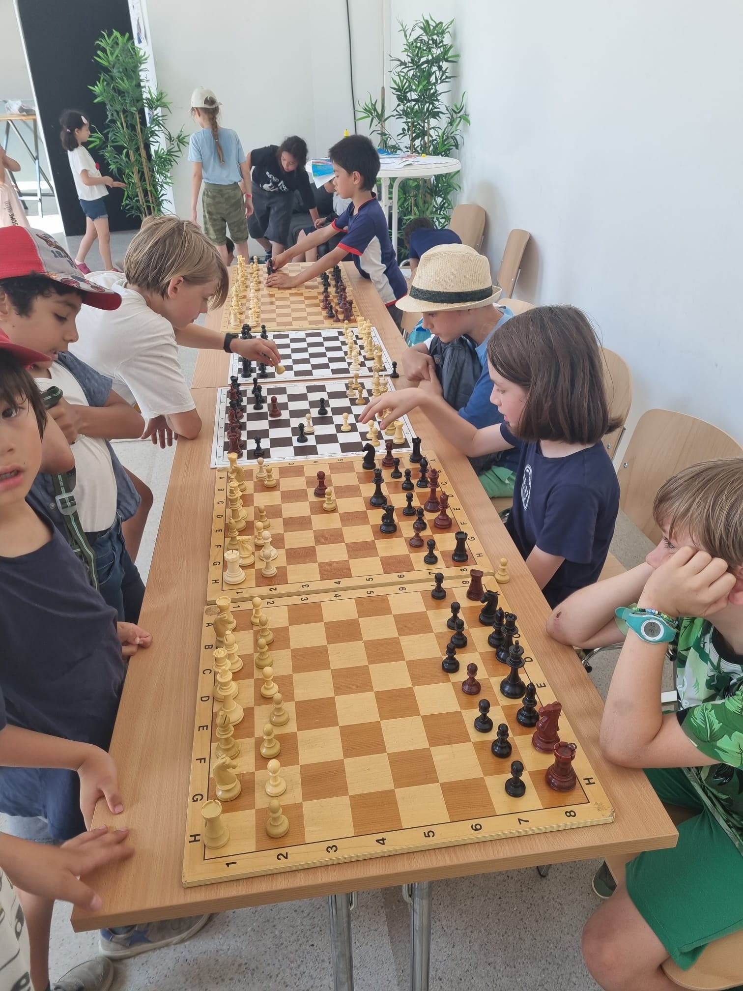 Enfants de l'atelier échec autour de tables de jeux