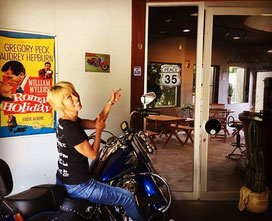 The owner with her Harley Davidson at the entrance