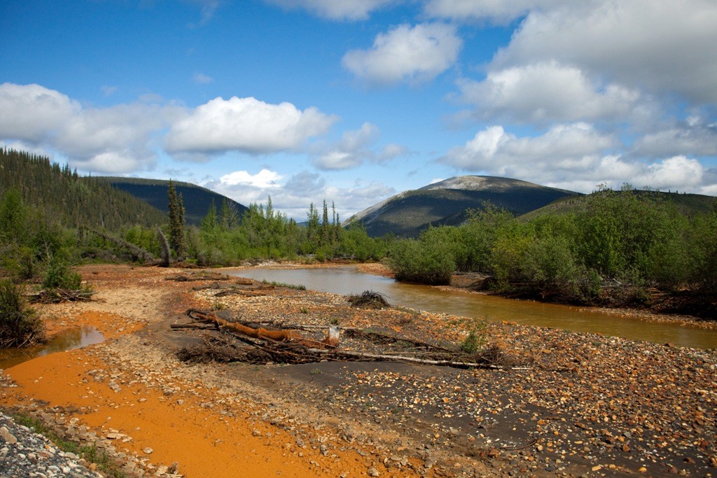 Blick auf den Red Creek, eindeutig erkennbar, die mineralischen Ablagerungen im und am Flussbett.
