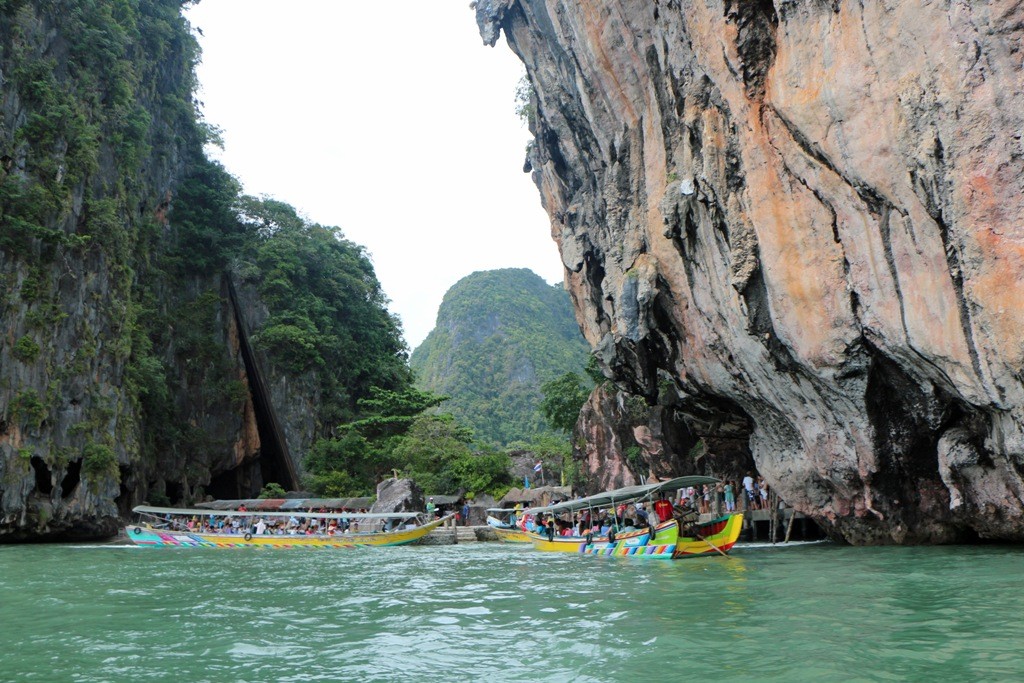 Der schmale Strand zwischen beiden Inseln (links Khao Phingkan), eingebettet zwischen hohen Kalksteinwänden von bis zu 300 m Höhe im Gedröhn der Longtailboot Motoren.