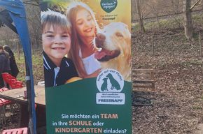 Werbebanner mit Bild eines lächelnden Golden Retrievers und Text: 'Sie möchten ein TEAM in Ihre SCHULE oder KINDERGARTEN einladen?'