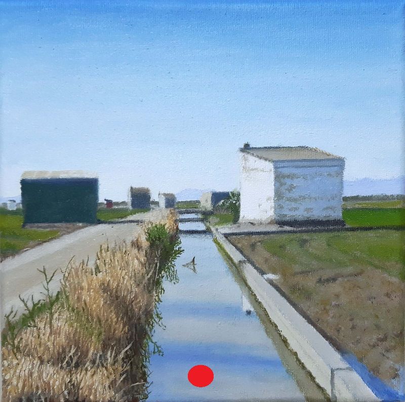 Canal rural con casetas blancas alineadas, campos a ambos lados y cielo despejado en un paisaje típico del camino de Recatí.
