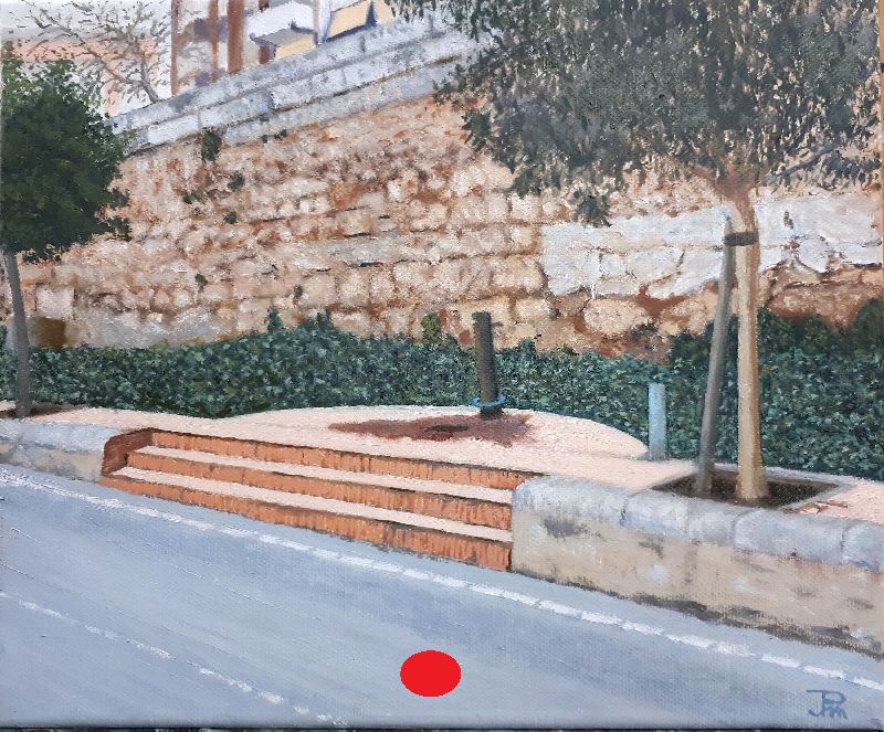 Fuente urbana junto a un muro de piedra y árboles, frente a las pistas del antiguo cauce del río Turia.
