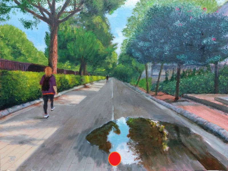 Camino del Jardín del Turia con un gran charco reflejando árboles y cielo, y dos personas paseando al fondo.