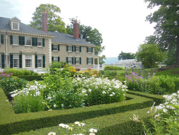 A formal garden at the back of the house with a view of the mountains