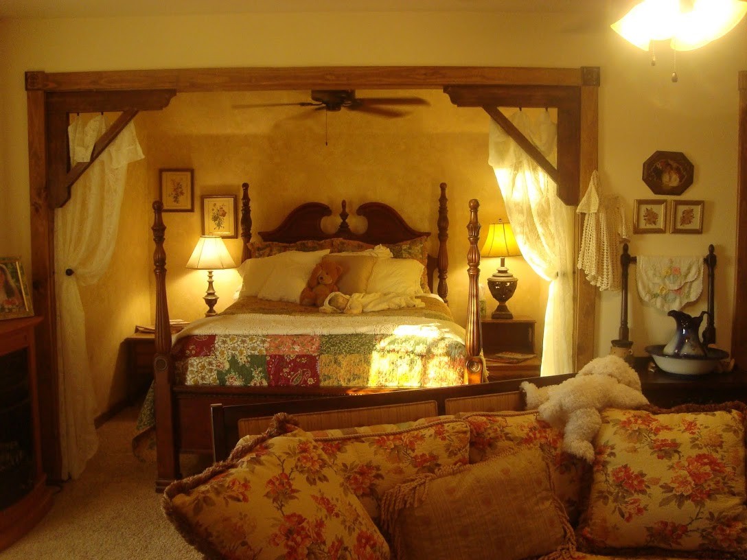 queen sized 4 poster bed with pillow top mattress tucked back in a cozy alcove